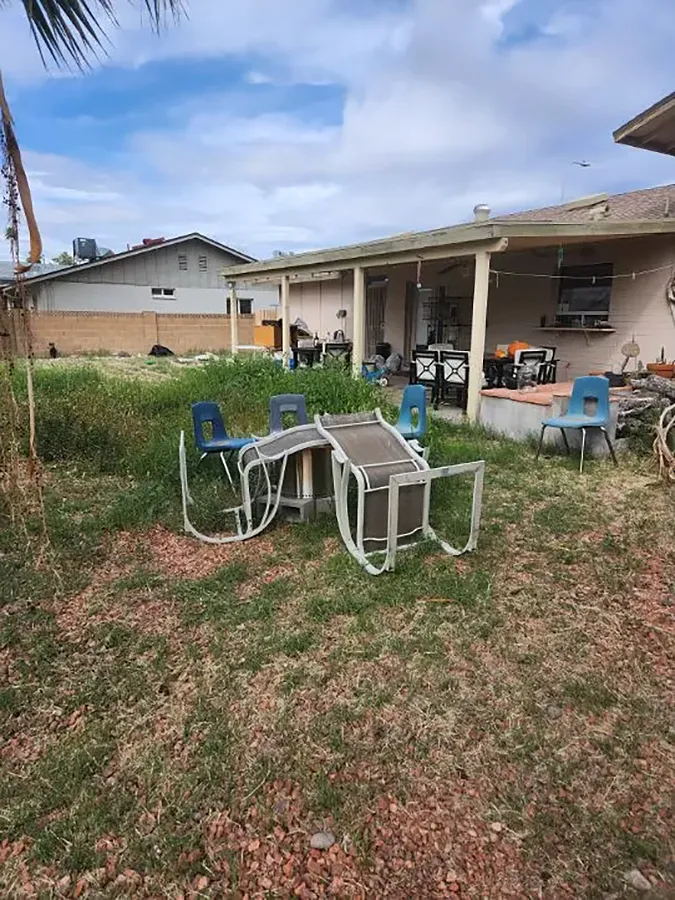 Before Image of horrible backyard with old chairs and sparse lawn.