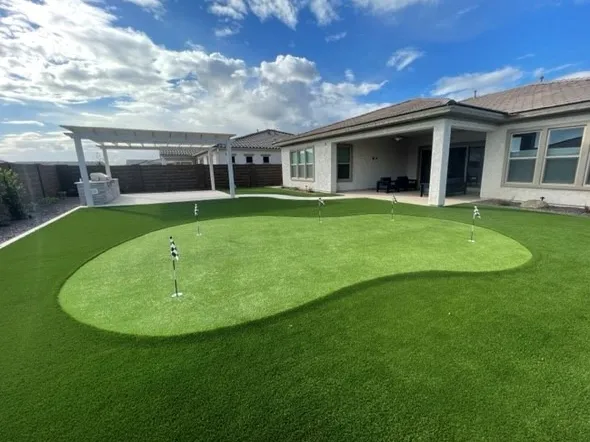 Beautiful backyard with putting green, pergola, barbecue and new pavers.