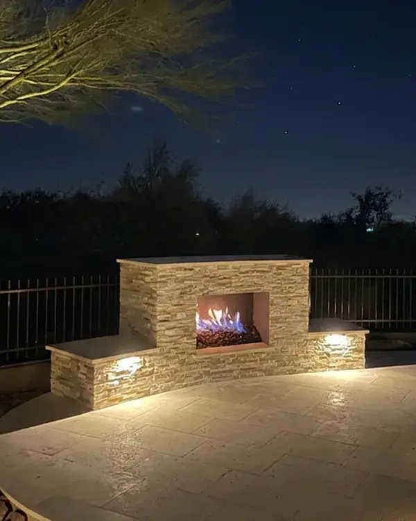 Outdoor fireplace at night installed by Colorworks Landscaping
